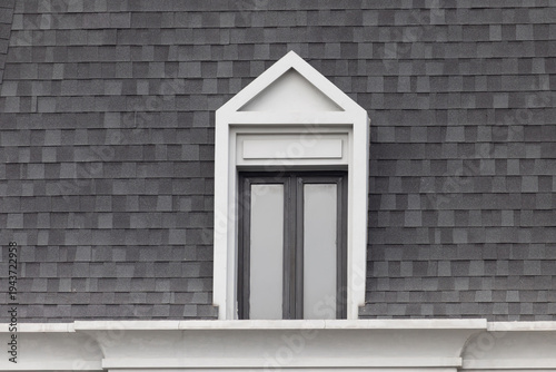 Fotografi White-framed dormer window set in dark gray shingle roof