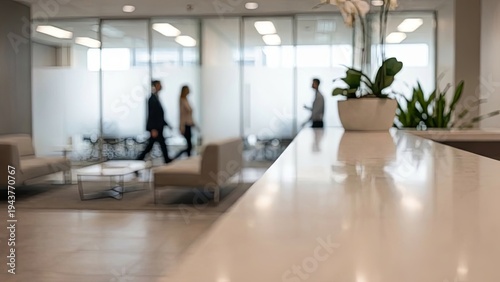 Modern office reception with blurred business people walking by.