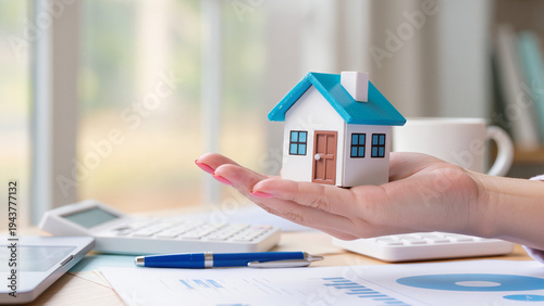 real estate concept, financial journey toward homeownership, showcasing miniature houses held in hands alongside money, piggy banks, calculators, and keys to symbolize real estate investment 