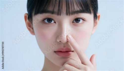 鼻先を指差す若い女性の正面ポートレート
