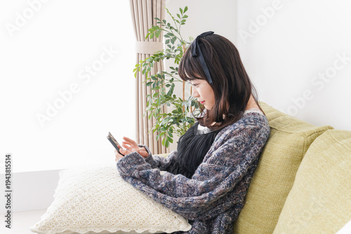 Foto 家でスマートフォンを使う若い女性