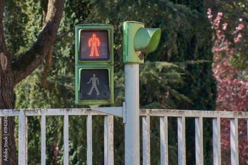 Pedestrian traffic light with an illuminated red human figure indicating no entry in the city