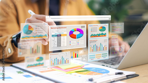 Business professional analyzing marketing dashboard with data charts on laptop and tablet. Concept of data analytics, business intelligence, and strategy.