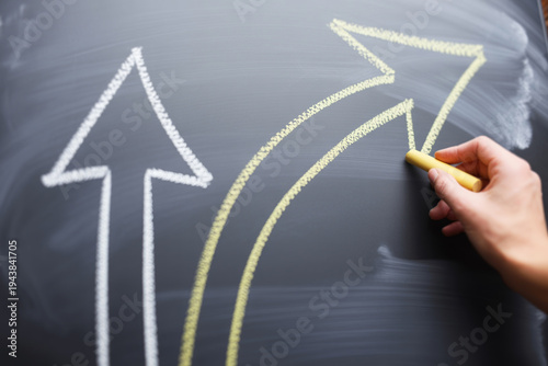 Chalk drawing of diverging arrows on blackboard representing choices
