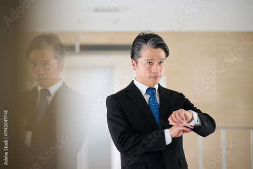 Tableau sur toile オフィスの廊下で時計を確認する50代男性ビジネスマン
