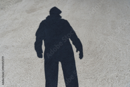 Dark shadow of a lonely person on the ground in the street. Stranger. Anxiety, depression, loneliness, fear concept. 