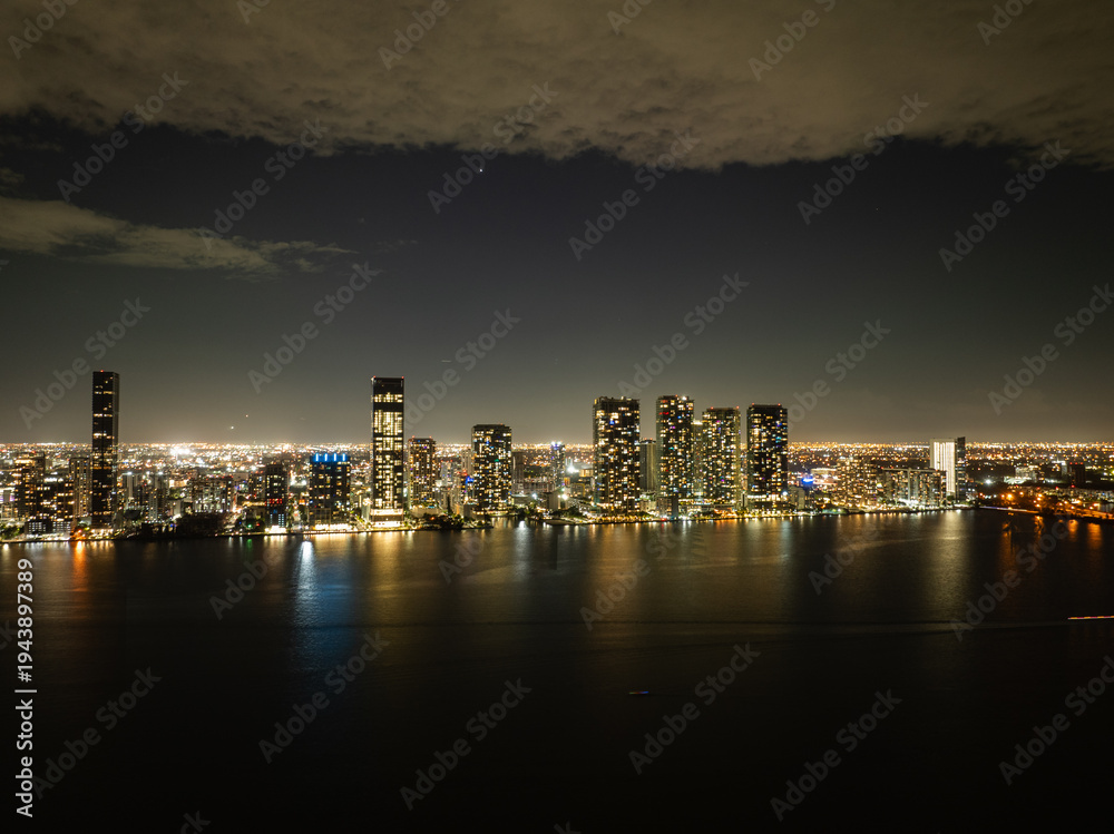 Fototapeta premium Miami downtown skyline at night reflected in Biscayne Bay, aerial cityscape