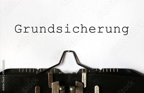 Grundsicherung auf Papier geschrieben mit Schreibmaschine – Konzept für Sozialhilfe, Existenzminimum und staatliche Unterstützung