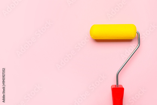 Paint roller on pink backgr...