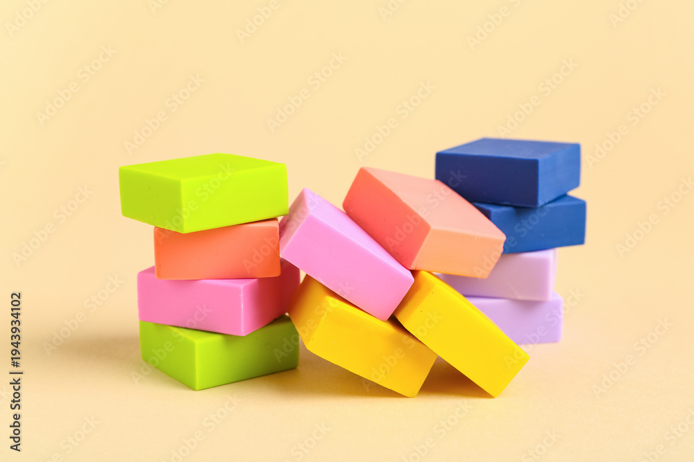 Fototapeta premium Colorful rubber erasers on beige background