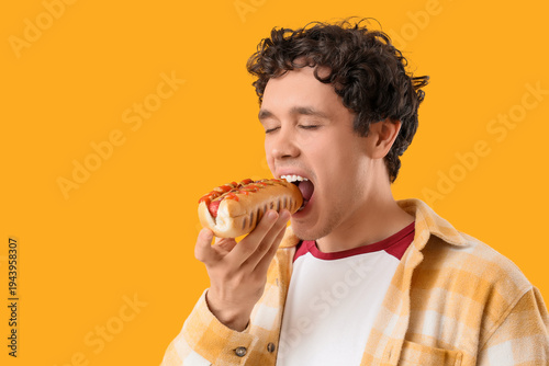Young man eating tasty hot ...