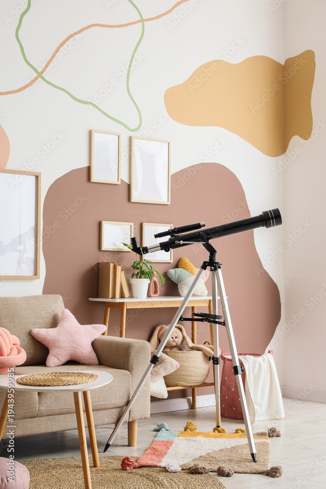 Fototapeta premium Interior of stylish children's room with sofa, toys and modern telescope