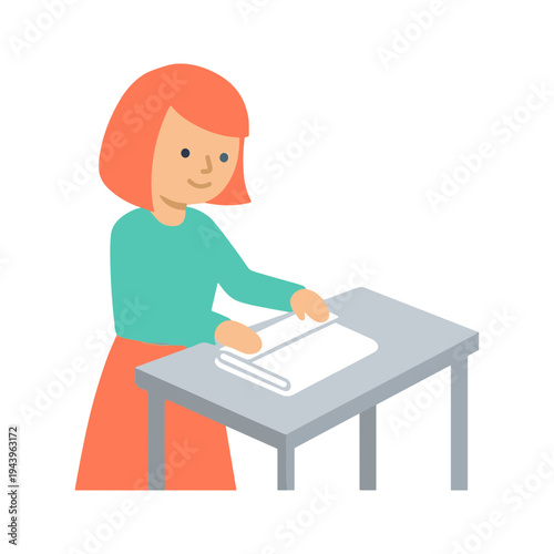 A woman folding paper on a gray table indoors.