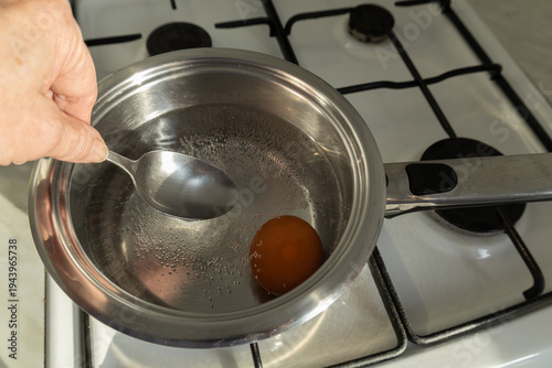 Placing egg in boiling water