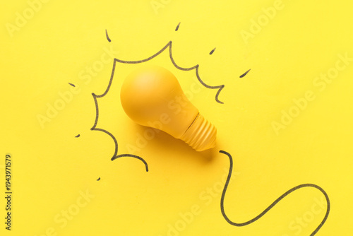 Foto Light bulb with drawing on yellow background