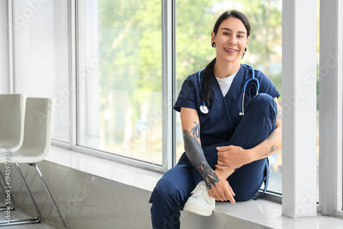 Tattooed female doctor sitt...