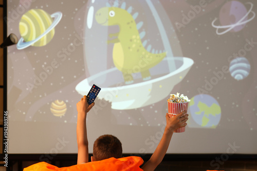Cute boy with popcorn and T...