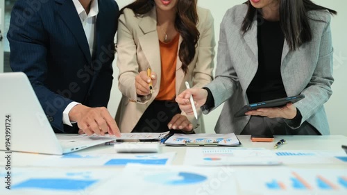 Business documents on office table with smart phone and calculator digital tablet and graph business with social network diagram and two colleagues discussing data working in the office