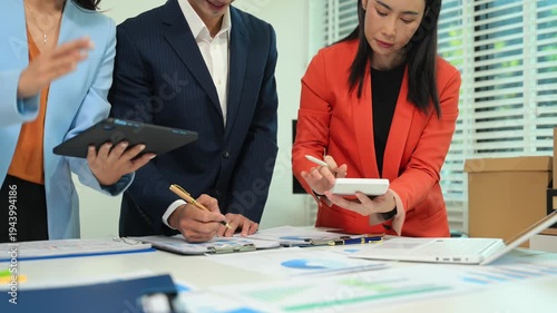 Business documents on office table with smart phone and calculator digital tablet and graph business with social network diagram and two colleagues discussing data working in the office