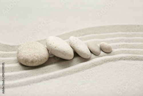 Photography Composition with spa stones and lines on sand as background, closeup