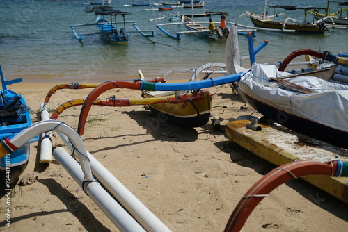 Traditional Balinese fishing boats in shallow water and on the beach