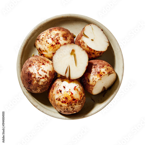 A bowl of unpeeled potatoes with one cut in half on a plain background isolated on transparent background