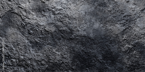 A textured black stone wall background featuring a rough granite pattern with aged grunge details and a grey cement surface for modern architectural design