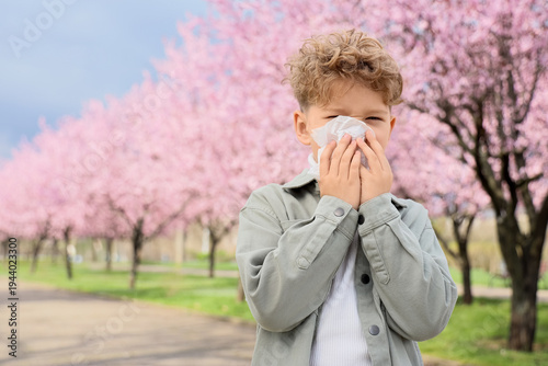 Sick little boy with tissue...