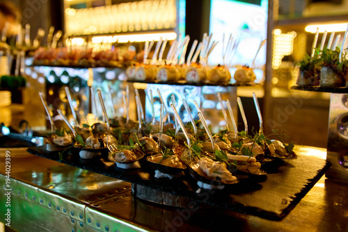 Gourmet seafood appetizers served on a slate tray at a corporate banquet. Professional catering service for business events and holiday parties with warm golden bokeh lights and copy space.