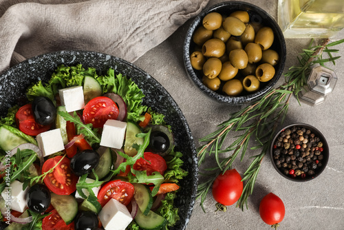 Bowl of fresh Greek salad with ingredients on grunge background
