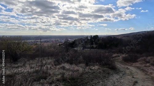 View over valley landscape with dramatic clouds and distant Bratislava skyline