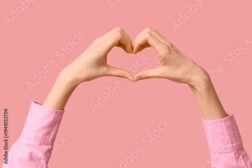Young woman making heart ge...