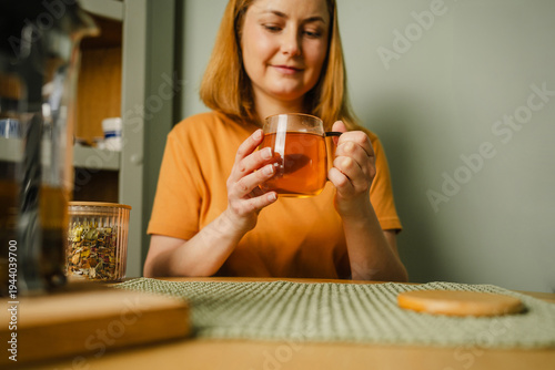 Woman enjoying organic herbal tea indoors at home