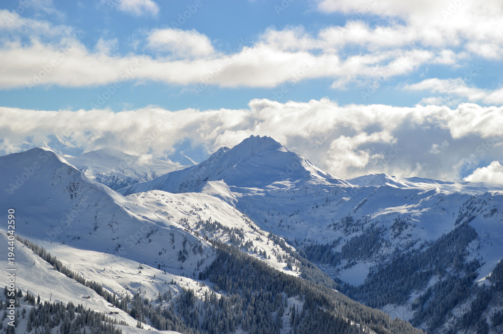 Obraz premium Majestic snow-covered alpine mountains rise under a brilliant bl