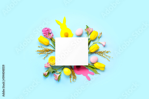Blank card with Easter eggs, paper bunnies and flowers on blue background