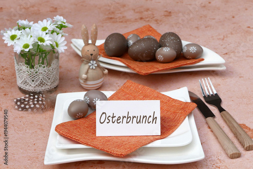 Gedeckter Ostertisch mit Osterdekoration und einer Tischkarte mit der Beschriftung Osterbrunch.