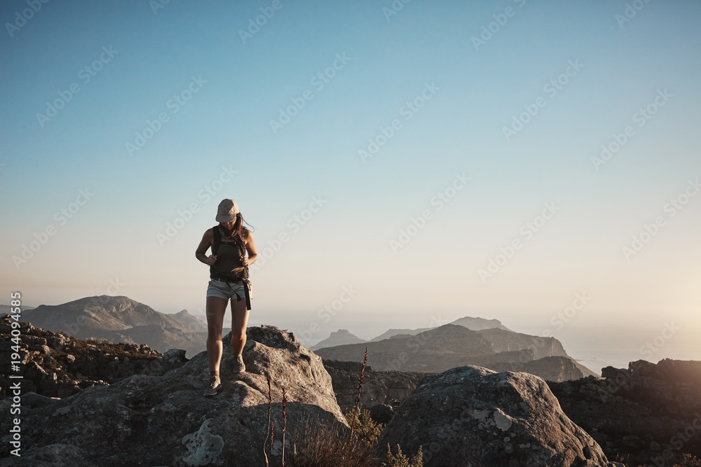 Fototapeta premium Hiking, mountain and walk with woman in nature for adventure, blue sky space and travel holiday. Explore, tourism vacation and trekking with person on rock hill for journey, backpacking and wellness