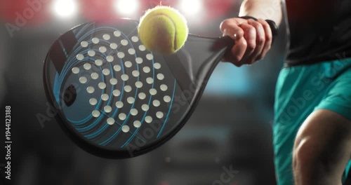 Super slow motion close-up of a hand holding a padel racket as a yellow ball hits the surface, filmed at 1000 fps. Dramatic studio lighting highlights the impact, motion of the racket and ball.