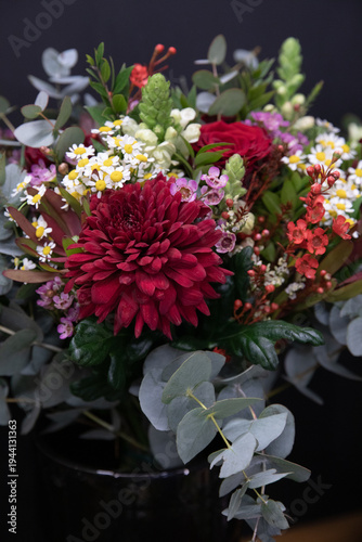 Bouquet with red chrysanthemum, roses and spring flowers in florist shop during day.