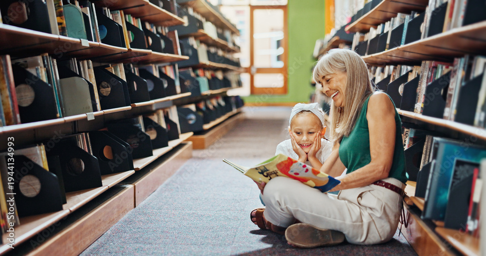 Fototapeta premium Grandmother, reading book and girl in library, smile and bonding together for child development. Senior woman, kid or family on floor, happiness and support for education, literacy, hobby or teaching