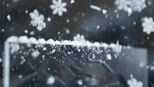 Extreme close-up macro slow motion large detailed snowflakes accumulating sticking to dark surface during winter snowstorm, for cold weather seasonal change
