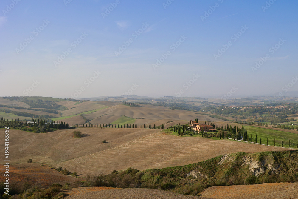 Obraz premium Farmhouse and cypress road in the autumn hills near Asciano, Tuscany, Italy