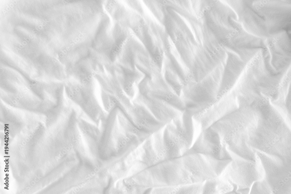 Fototapeta premium Close-up of white fabric texture with soft natural wrinkles and subtle woven textile pattern. Minimal neutral cloth background suitable for design, fashion, and abstract texture concepts.