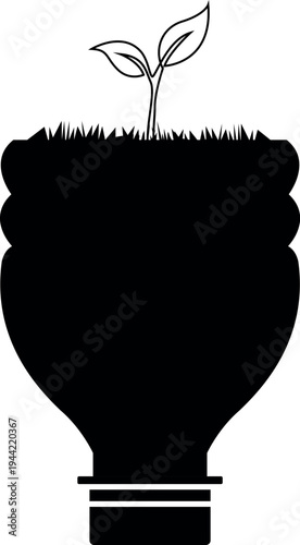 A young plant grows from a recycled plastic bottle