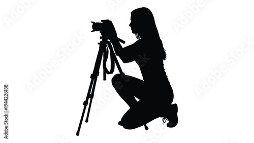 A silhouette of a female photographer kneeling while adjusting her camera on a tripod, capturing the perfect shot with precision and care.