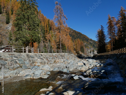 Autumn in the Alps. Chardonney, a hamlet of Champorcher, Aosta Valley, Alps, Italy. Along the river bottom.
