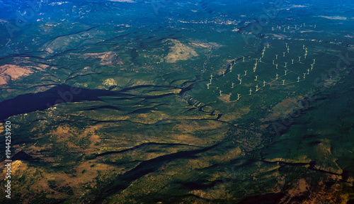 Bird's eye view of wind turbines farm in mountain range.