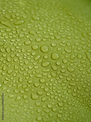 Obraz na plátně Water drops on green waterproof fabric.