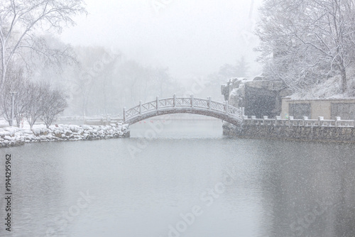A winter snow scene of a stone bridge