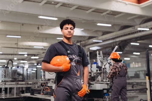 Foto Young worker standing confident in manufacturing factory